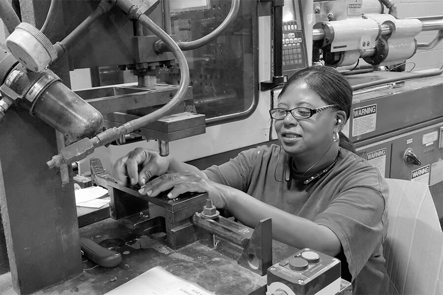 woman plastic injection molding worker at a machine